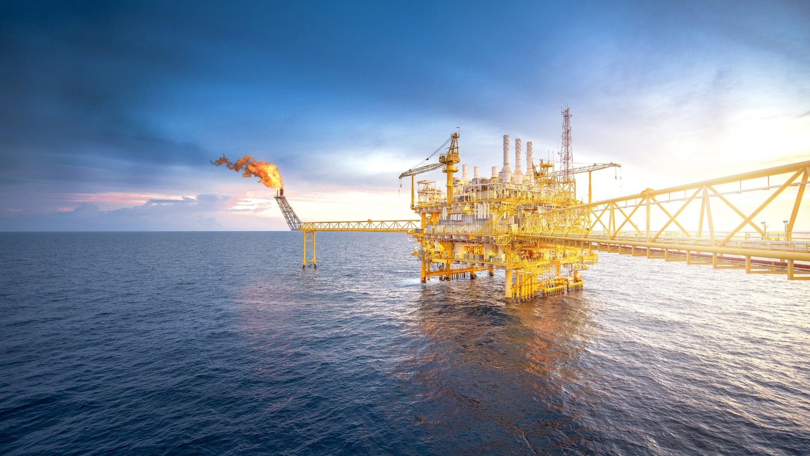 Gulf production at dusk: an offshore platform flaring as supply returns to a contested Asian market