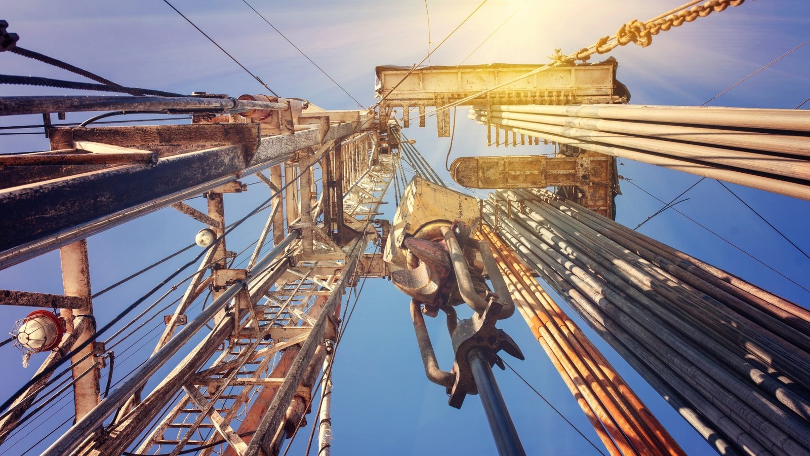 Looking up a drilling derrick against a bright sky, the prominence a brand builds to stay top of mind.