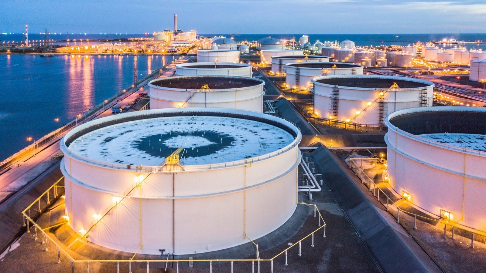 Crude oil storage tanks at dusk. Spare capacity is the buffer that can be brought online within 30 days.