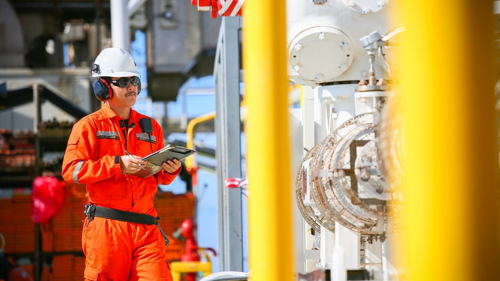 An engineer inspecting process equipment against a bright yellow structure. The proof that decides an energy purchase, the certification, the duty rating, the registration status, is usually the proof that never makes it into machine-readable text.