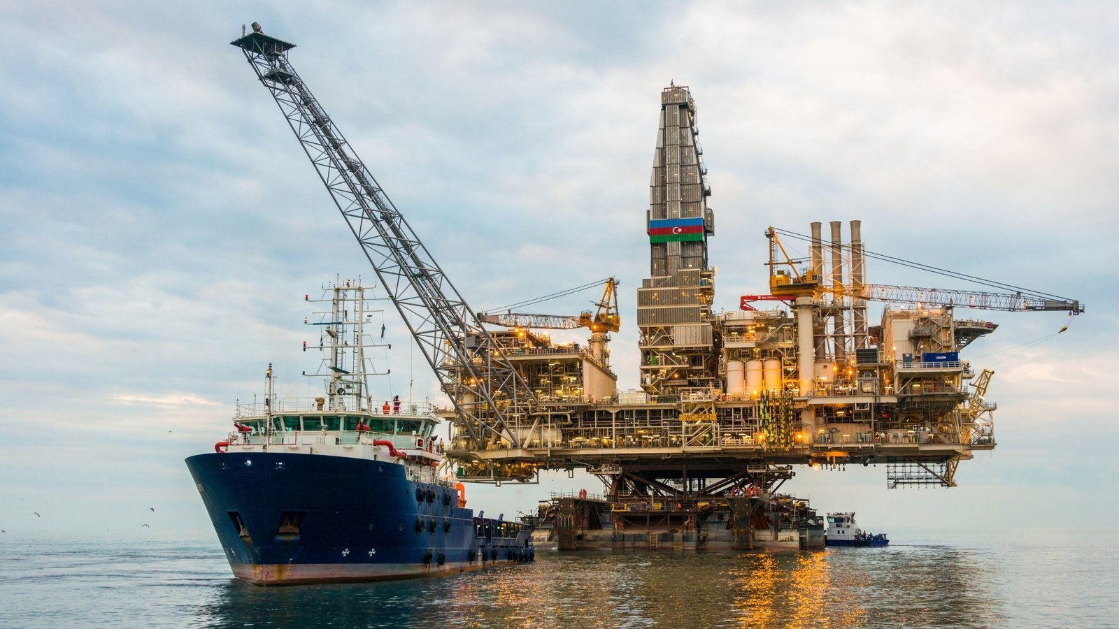 Jack-up drilling rig alongside a heavy lift vessel offshore