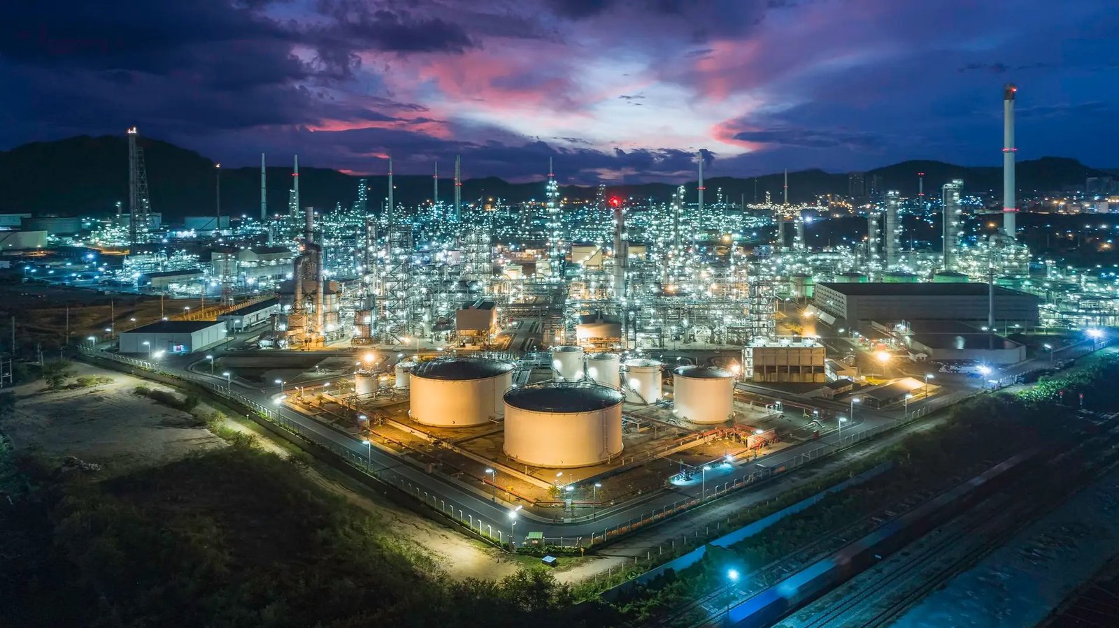 An integrated gas and chemicals complex at night. XRG's mandate is concentrated on gas, chemicals and the infrastructure behind rising power demand, which is a narrower remit than any sovereign wealth fund would carry.