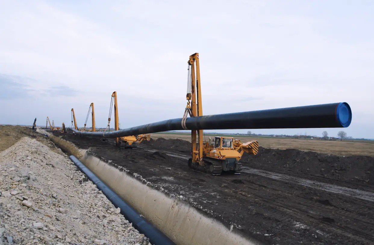 Pipeline construction, sections lowered into a prepared trench. Mental availability is built the same way, laid in advance of the demand it will carry, and measured by whether it is there when the flow starts.